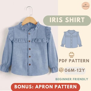 Può includere: Una camicia Iris azzurra con dettagli a balze, maniche lunghe e bottoni in legno, esposta su una gruccia di legno. L'immagine include anche il testo "IRIS SHIRT", "PDF PATTERN", "06M-12Y", "BEGINNER FRIENDLY" e "BONUS: APRON PATTERN".