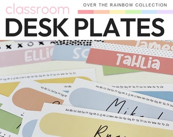 Può includere: Placche da scrivania colorate con nomi come "Ryan", "Mikai", "TaHlia" e "Elli" in uno schema di colori arcobaleno. Le placche hanno una linea di numeri e una tabella dell'alfabeto per l'uso in classe. Il testo "easy to edit designs" è nella parte inferiore dell'immagine.