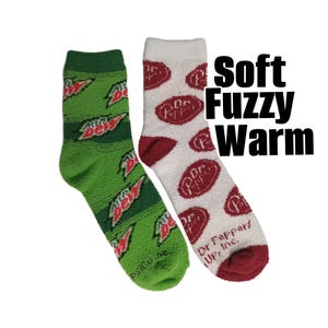 May include: Two pairs of fuzzy socks. One pair is green with a repeating Mountain Dew logo. The other pair is white with repeating Dr. Pepper logos and red accents. The text "Soft Fuzzy Warm" is in the image.