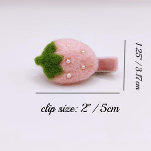 Puede incluir: Una pinza para el pelo de fresa de fieltro rosa con detalles de perlas blancas y una hoja de fieltro verde. La pinza mide 3,17 cm de largo y el tama&ntilde;o de la pinza es de 5 cm.