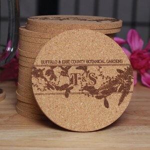 May include: A stack of cork coasters with a floral design and the text "Buffalo & Erie County Botanical Gardens" and "T&S".