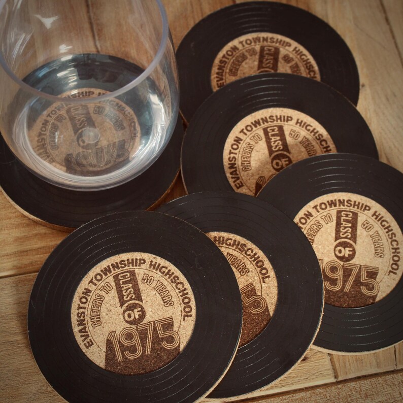May include: Six black and brown cork coasters with a vinyl record design. The coasters feature the text "Evanston Township High School" and "Class of 1975".