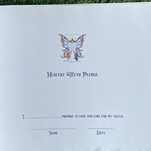以下が含まれることがあります： 白いページに、紫と青の蝶のイラストと「HEALTHY TEETH PLEDGE.」というテキストが書かれています。ページには名前と日付の欄があり、「私は自分の歯を愛し、大切にすることを約束します。」というテキストが書かれています。