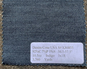 May include: A rectangular swatch of dark indigo denim fabric with a frayed edge. A white label displays text including "Denim Cone USA", "10.5oz", and "3,760 Yards". The fabric measures 56.5-57.5 inches wide.