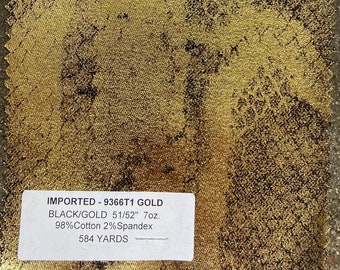 May include: A close-up of a gold fabric swatch with a black and gold speckled pattern. The fabric is labeled "IMPORTED - 9366T1 GOLD BLACK/GOLD 51/52" 7oz. 98% Cotton 2% Spandex 584 YARDS".