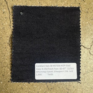 May include: A dark blue denim fabric swatch with the text "Candiani Italy S# KR7556-KOP Elast Color K-Old finish Pure 65-67" 11.5oz 66%Lenzingo-Lyocell 32% organic C 2%E 3x1R 2,300 Yards".
