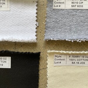 May include: Four fabric swatches, two white, one gray, and one beige. The swatches are labeled with the style, content, and lot number. The white swatches are labeled "F. TERRY 20 OZ 90/10 C/P SNT 9233" and "F. TERRY 18 OZ 100% COTTON SA 16 JOS". The gray swatch is labeled "F. TERRY 20 OZ 90/10 C/P SNT 9233". The beige swatch is labeled "F. TERRY 18 OZ 100% COTTON SA 16 JOS".