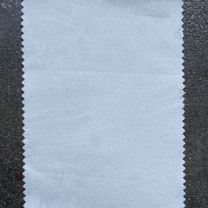 May include: A white fabric swatch with a scalloped edge.