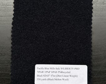 May include: A square swatch of black fabric with a textured surface and a scalloped edge. A white label provides details: "Pacific Blue Mills Italy S#LIBERTY-PBD" and fabric composition. The fabric is 62/63 inches wide and 17oz.