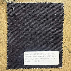 May include: A dark blue denim fabric swatch with a white label that reads "Candiani Italy S# KR7556-KOP Elast Color K-Old finish Pure 65-67" 11.5oz 66% Lenzingo-Lyocell 32% organic C 2%E 3x1k 2,300 Yards".