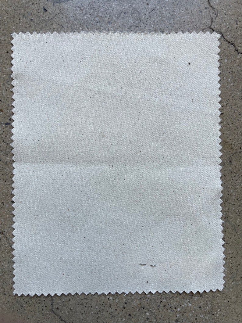 Puede incluir: Una muestra de tela blanca lisa con una superficie ligeramente texturizada. La tela tiene un borde festoneado.