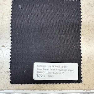 May include: A dark gray fabric swatch with the text "Candiani Italy S# RR5512-BR Color Blend finish Recycled (Indigo) 100%C 12oz 65.5-66.5" 3723 Yards"