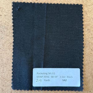 May include: A square swatch of black fabric with a jagged edge. A white label at the bottom displays text: "Pocketing S# J33, 65%P 35%C 58-59" 3.5oz Black, 210 Yards, SA2."