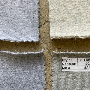 May include: Four fabric swatches with different colors and textures. The swatches are labeled with style, content, and lot numbers. The top left swatch is a light gray, the top right swatch is a light beige, the bottom left swatch is a medium gray, and the bottom right swatch is a dark gray.