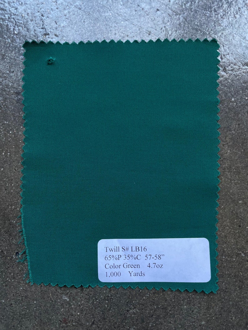 May include: A swatch of green twill fabric with the text "Twill S# LB16 65%P 35%C 57-58" Color Green 4.7oz 1,000 Yards"