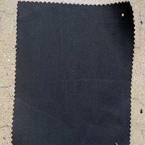 May include: A black fabric swatch with a textured weave.