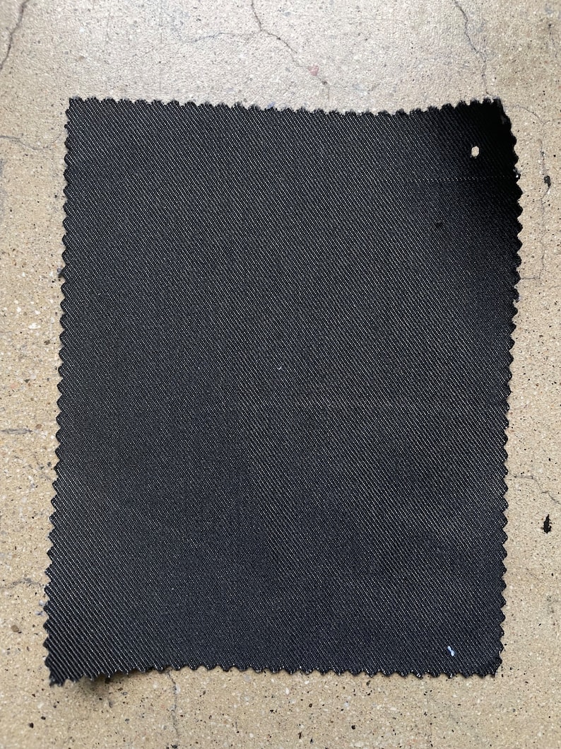 May include: A black fabric swatch with a textured weave.