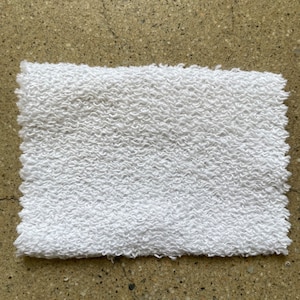 May include: White terry cloth fabric with a textured surface.