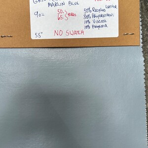 May include: A sample of blue fabric with a brown label that reads "GRNTEXTILE Co MARLIN BLUE" and includes the following information: 9 oz, 50-65 yards, 50% Recycled Leather, 30% Polyurethane, 10% Viscose, 10% Polyester, MUST BUY FULL ROLL, 55" NO SWATCH.