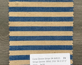 Può includere: Un campione di tessuto denim a righe con strisce orizzontali blu e beige alternate. Il tessuto ha un bordo grezzo nella parte superiore e un'etichetta con dettagli, tra cui "Cone Denim Stripe" e misure di 143.5-146 cm.
