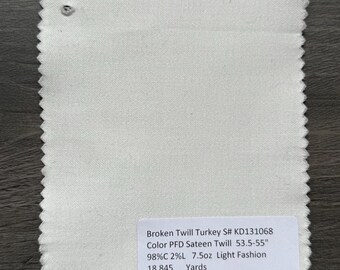 May include: A sample of off-white Broken Twill Turkey fabric. The label indicates it's Color PFD Sateen Twill, 53.5-55 inches wide, with a composition of 98% cotton and 2% linen. It weighs 7.5oz and is intended for light fashion use. The sample has a jagged edge.