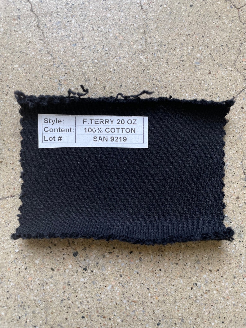 May include: Black fabric swatch with a white label that reads "Style: F. Terry 20 oz Content: 100% Cotton Lot #: SAN 9219"