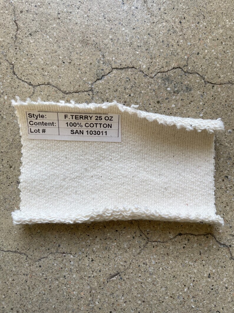 May include: A white cotton fabric swatch with a label that reads "Style: F. TERRY 25 OZ, Content: 100% COTTON, Lot #: SAN 103011".