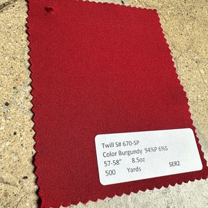 May include: A burgundy twill fabric swatch with the text "Twill S# 670-SP Color Burgundy 94%P 6%S 57-58" 8.5oz 500 Yards SER2".