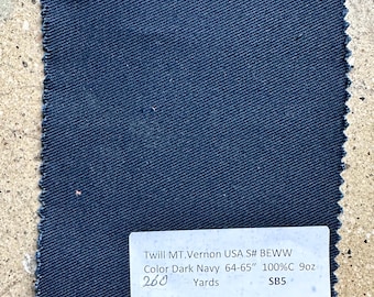 Può includere: Un campione di tessuto in twill blu scuro con un'etichetta che recita "Twill MT.Vernon USA S# BEWW Color Dark Navy 64-65" 100%C 9oz 260 Yards SB5"