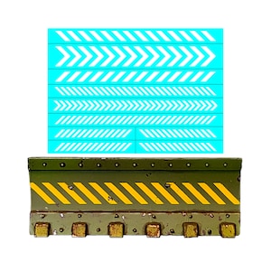 May include: A green metal barrier with yellow and black chevron stripes. The barrier has a series of rivets along the top and bottom edges. The barrier is designed to be used as a safety measure.