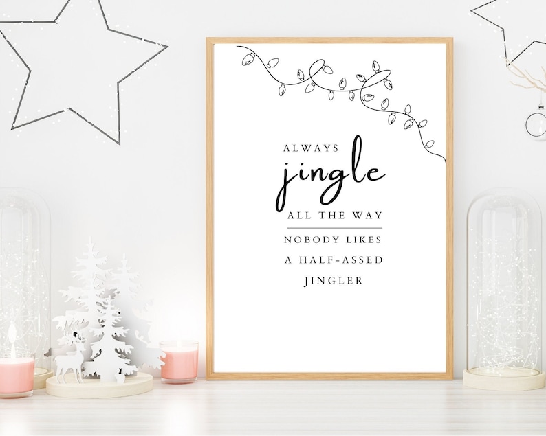 May include: A white printable poster with a black border and a Christmas-themed quote that reads "Always jingle all the way. Nobody likes a half-assed jingler." The quote is surrounded by a simple line drawing of a string of Christmas lights.