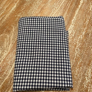 May include: A folded black and white gingham fabric with a frayed edge.