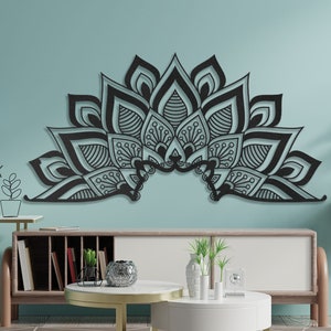 Puede incluir: Decoraci&oacute;n de pared de metal negro en forma de un gran mandala con intrincados detalles. El mandala est&aacute; montado en una pared azul claro en un sal&oacute;n.