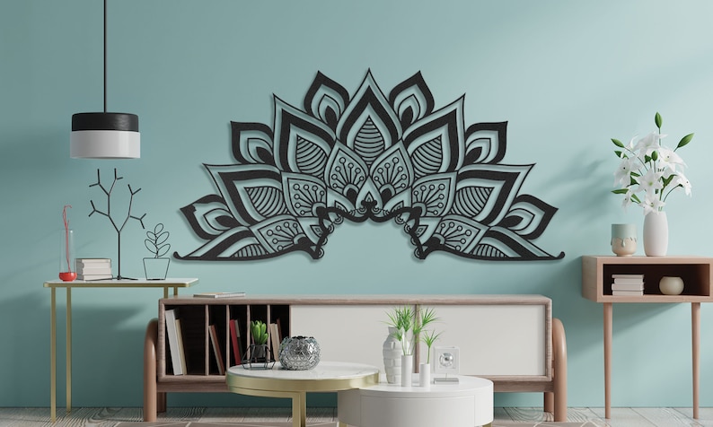 Puede incluir: Decoraci&oacute;n de pared de metal negro en forma de un gran mandala con intrincados detalles. El mandala est&aacute; montado en una pared azul claro en un sal&oacute;n.