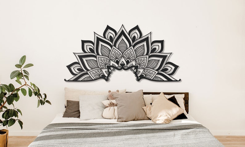 Puede incluir: Decoraci&oacute;n de pared de mandala en blanco y negro con detalles intrincados, colgada sobre una cama con almohadas y una colcha blanca.