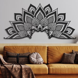 Puede incluir: Una decoraci&oacute;n de pared de metal negro en forma de medio c&iacute;rculo mandala con intrincados patrones florales. La decoraci&oacute;n est&aacute; montada en una pared gris sobre un sof&aacute; marr&oacute;n.
