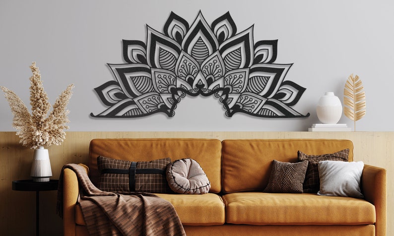 Puede incluir: Una decoraci&oacute;n de pared de metal negro en forma de medio c&iacute;rculo mandala con intrincados patrones florales. La decoraci&oacute;n est&aacute; montada en una pared gris sobre un sof&aacute; marr&oacute;n.