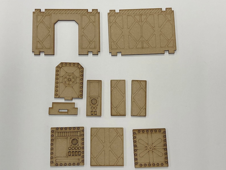Puede incluir: Un conjunto de piezas de madera sin terminar, cortadas con l&aacute;ser, para una estructura en miniatura de ciencia ficci&oacute;n o industrial. El conjunto incluye paredes, puertas y paneles con dise&ntilde;os geom&eacute;tricos y mec&aacute;nicos, listos para montar y pintar.