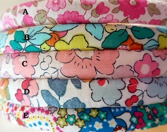 May include: Five different fabric swatches with floral patterns. The swatches are arranged in a stack, with the top swatch labeled "A" and the bottom swatch labeled "E".