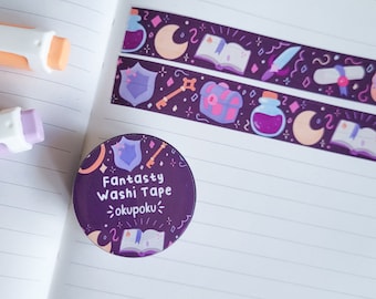 May include: A purple and pink washi tape roll with a fantasy theme. The tape features illustrations of a key, a shield, a chest, a potion bottle, a book, and a crescent moon. The text on the roll reads "Fantasity Washi Tape ~okupoku~."