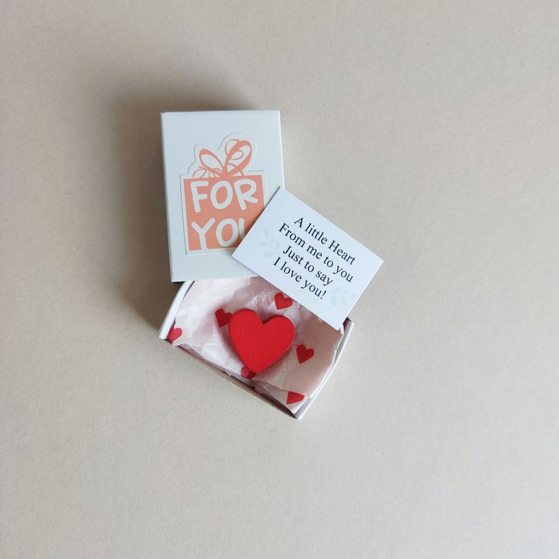 May include: A small white box with a red heart inside. The box has a pink and white label that says "FOR YOU". A separate card reads "A little Heart From me to you Just to say I love you!"