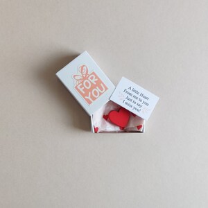 May include: A small white box with a red heart inside. The box has a sticker on it that says "FOR YOU". The box also has a small card that says "A little Heart From me to you Just to say I miss you!"
