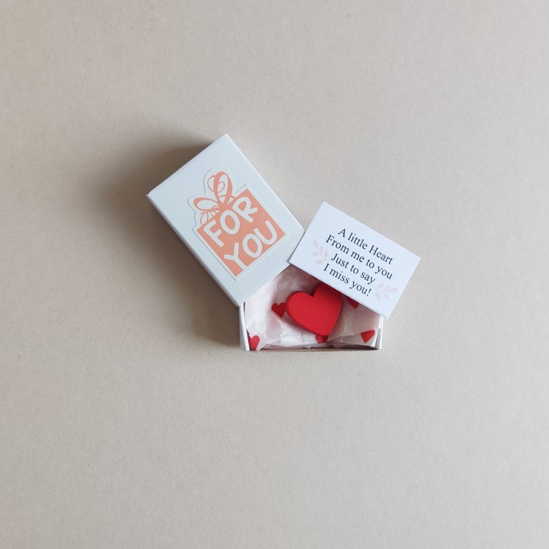 May include: A small white box with a red heart inside. The box has a sticker on it that says "FOR YOU". The box also has a small card that says "A little Heart From me to you Just to say I miss you!"