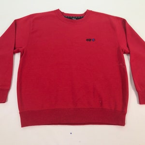 May include: Red long-sleeve sweatshirt with a small embroidered logo that says "elf" with a circle around the "o".