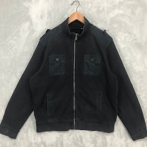 May include: Black zip-up jacket with a stand-up collar and two front pockets with button closures. The jacket has shoulder epaulettes and is hanging on a wooden hanger. The jacket is made of a dark fabric.