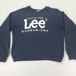 Op de afbeelding: Een marineblauw sweatshirt met lange mouwen met een wit Lee-logo en de tekst "Since 1889" en "Kansas-USA".