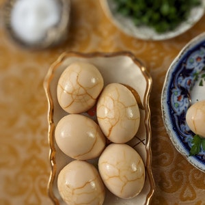 Carte de voeux vierge de Pessah avec des oeufs sépharades sur la table du Seder.