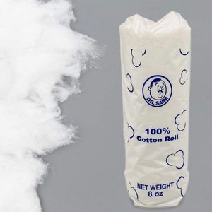 May include: A white cotton roll in a clear plastic package with blue accents. The package features the text "DR. SANA" and "100% Cotton Roll." The net weight is 8 oz. Loose cotton is visible to the left.