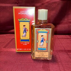 Pode incluir: Uma garrafa vintage de perfume "Lotion Pompeia" com sua caixa original. A garrafa e a caixa apresentam um esquema de cores vermelho e dourado com uma ilustra&ccedil;&atilde;o de uma mulher em um vestido cl&aacute;ssico. A garrafa cont&eacute;m 100 ml de perfume.