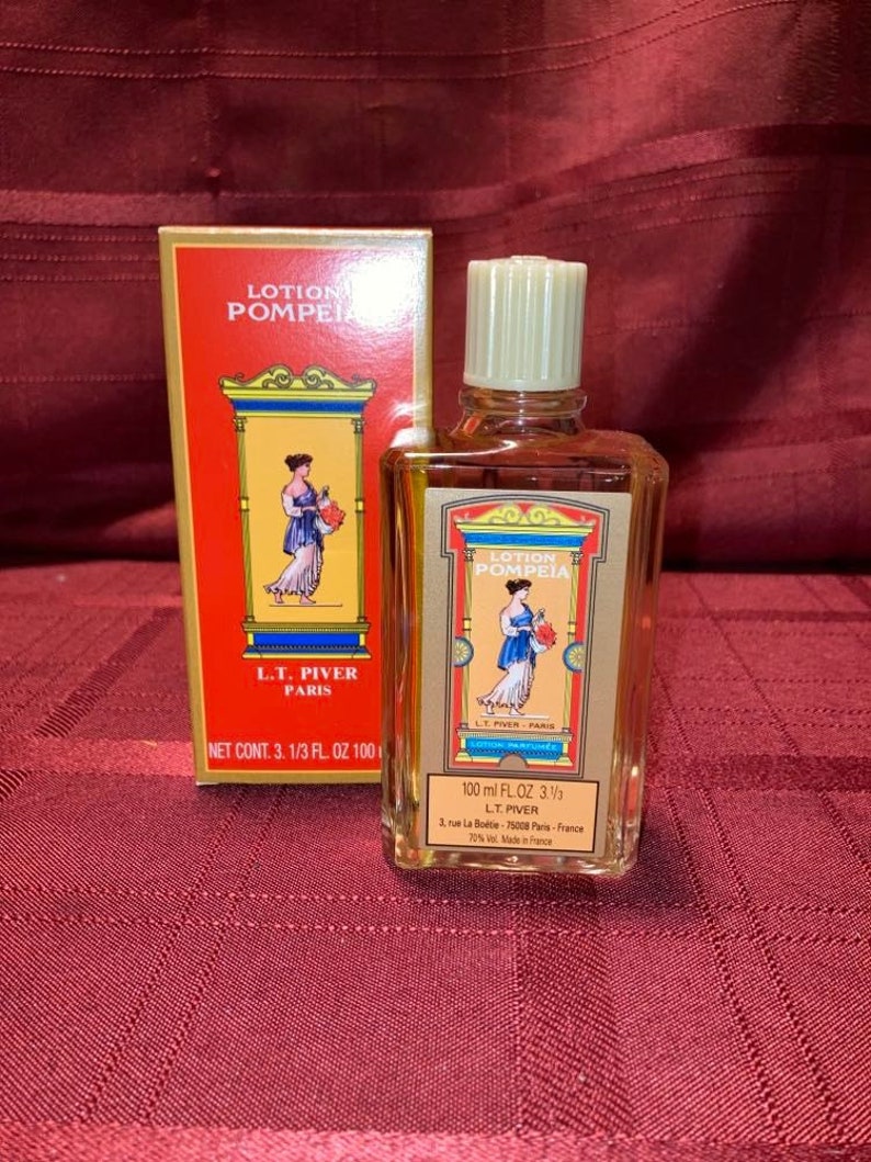 Pode incluir: Uma garrafa vintage de perfume "Lotion Pompeia" com sua caixa original. A garrafa e a caixa apresentam um esquema de cores vermelho e dourado com uma ilustra&ccedil;&atilde;o de uma mulher em um vestido cl&aacute;ssico. A garrafa cont&eacute;m 100 ml de perfume.